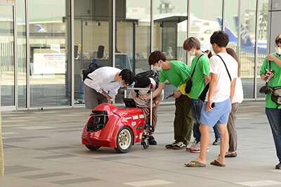 小型移動ロボットの説明をする学生たち